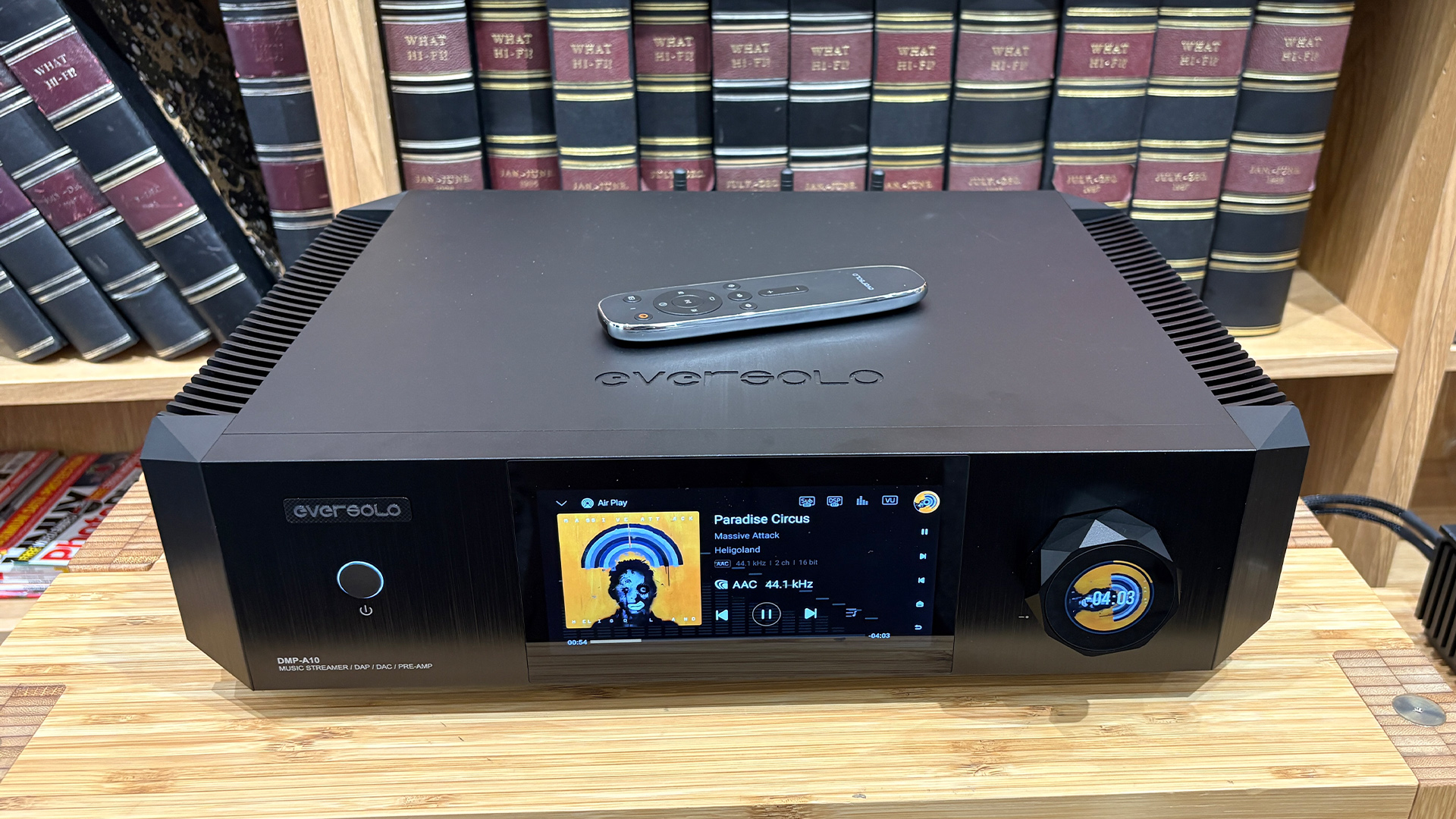Eversolo DMP-A10 streaming amplifier in front of bookcase with remote control on top of unit