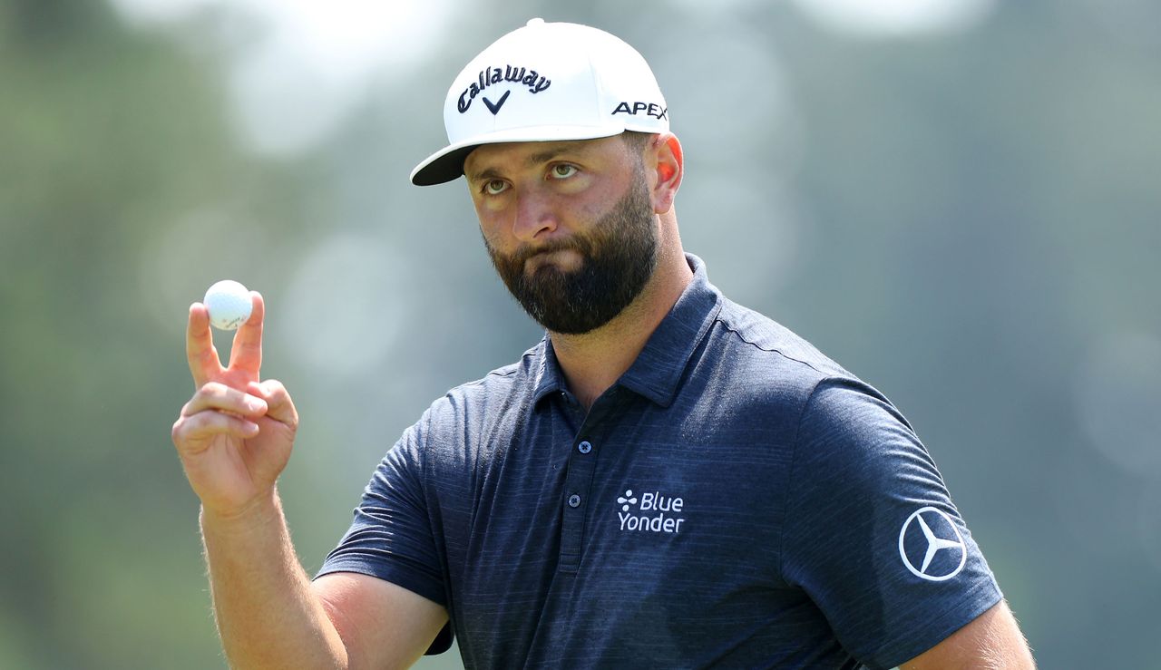 Rahm waves to the crowd after holing his putt on the 18th