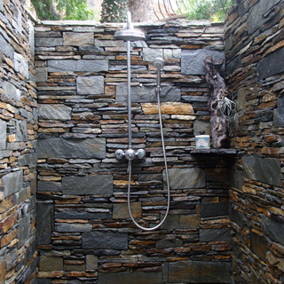 outdoor shower made up of stone wood and slate