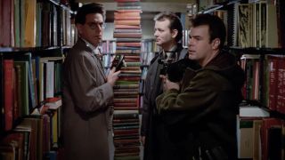 Harold Ramis, Bill Murray and Dan Aykroyd standing around a stack of books in Ghostbusters.