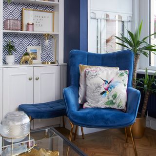 living room with cushion on blue chair and potted plant