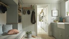 boot room storage with pale blue cabinets and upholstered bench