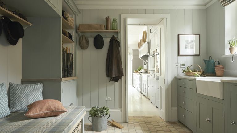 boot room storage with pale blue cabinets and upholstered bench