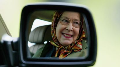 Queen Elizabeth II&#039;&#039;s smiling reflection in the mirror of her Land Rover