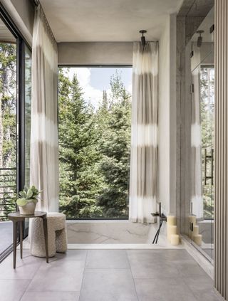 A bathroom with long curtains framing views