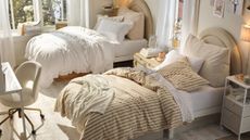 Stylish neutral dorm room with striped and ruffled bedding, matching arched headboards, and clever storage scattered throughout