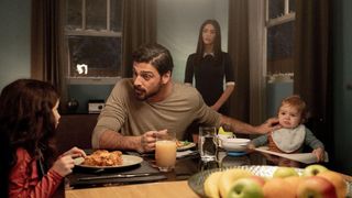 Nick (Michele Morrone) eats with his family while Alice (Megan Fox) stands behind them in the 2024 thriller, "Subservience"