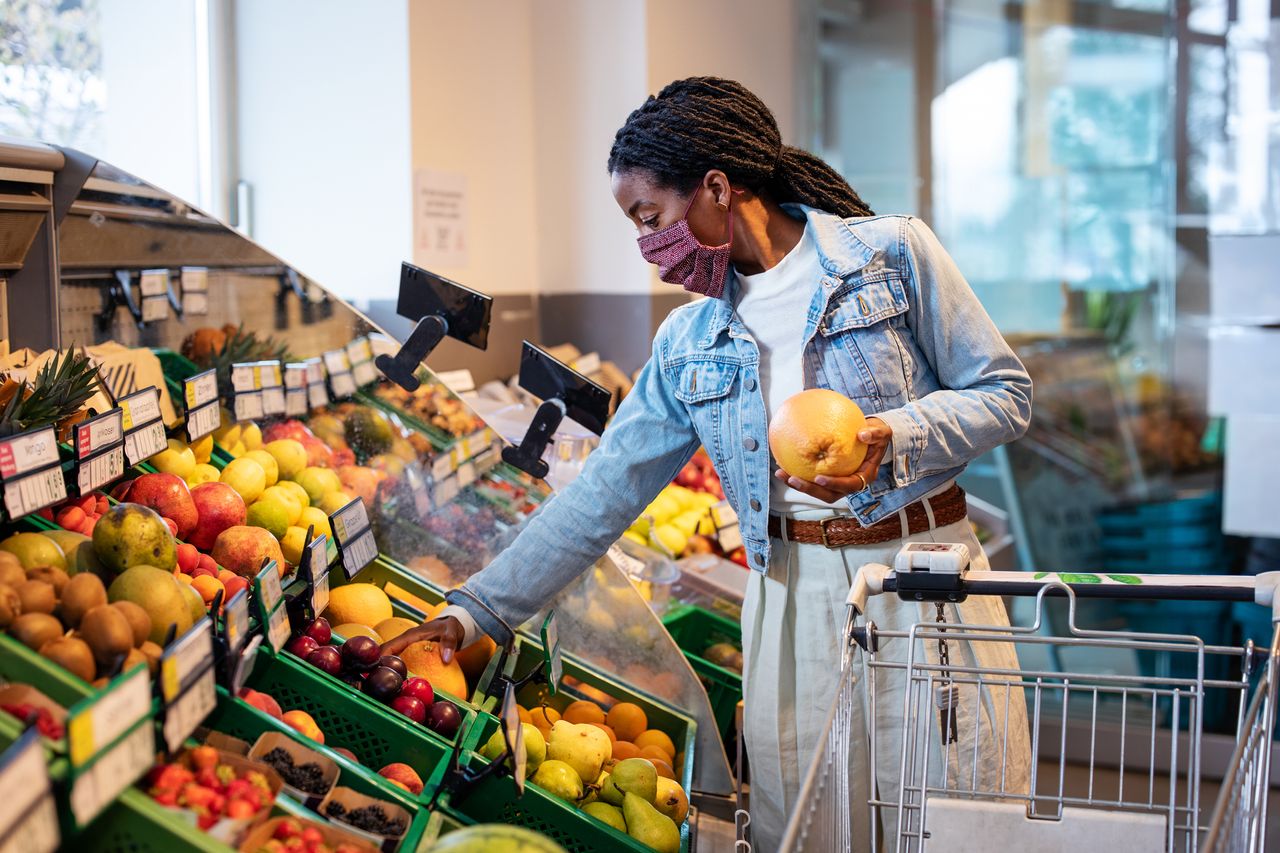 How many servings of fruit and vegetables per day: Female shopping fruits in grocery shop