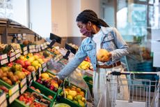 How many servings of fruit and vegetables per day: Female shopping fruits in grocery shop