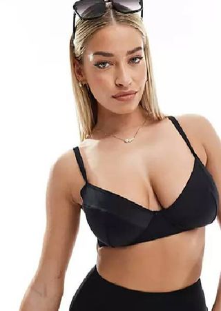 A model wearing a black bikini top from ASOS.