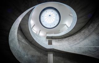 The concrete spiral staircase with a skylight at the top.