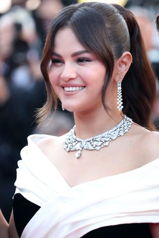 Selena Gomez on the cannes red carpet wearing a black and white gown and diamond jewelry