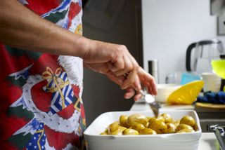 Man prepares new potatoes for Christmas dinner