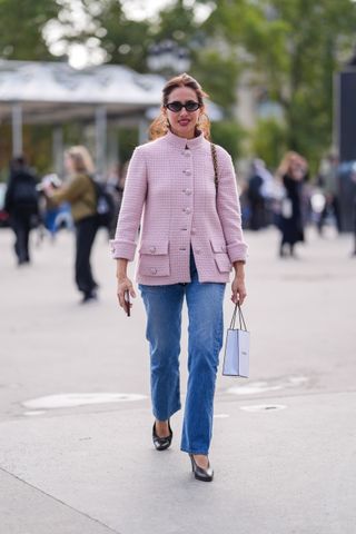 Woman in straight-leg jeans and pink jacket.