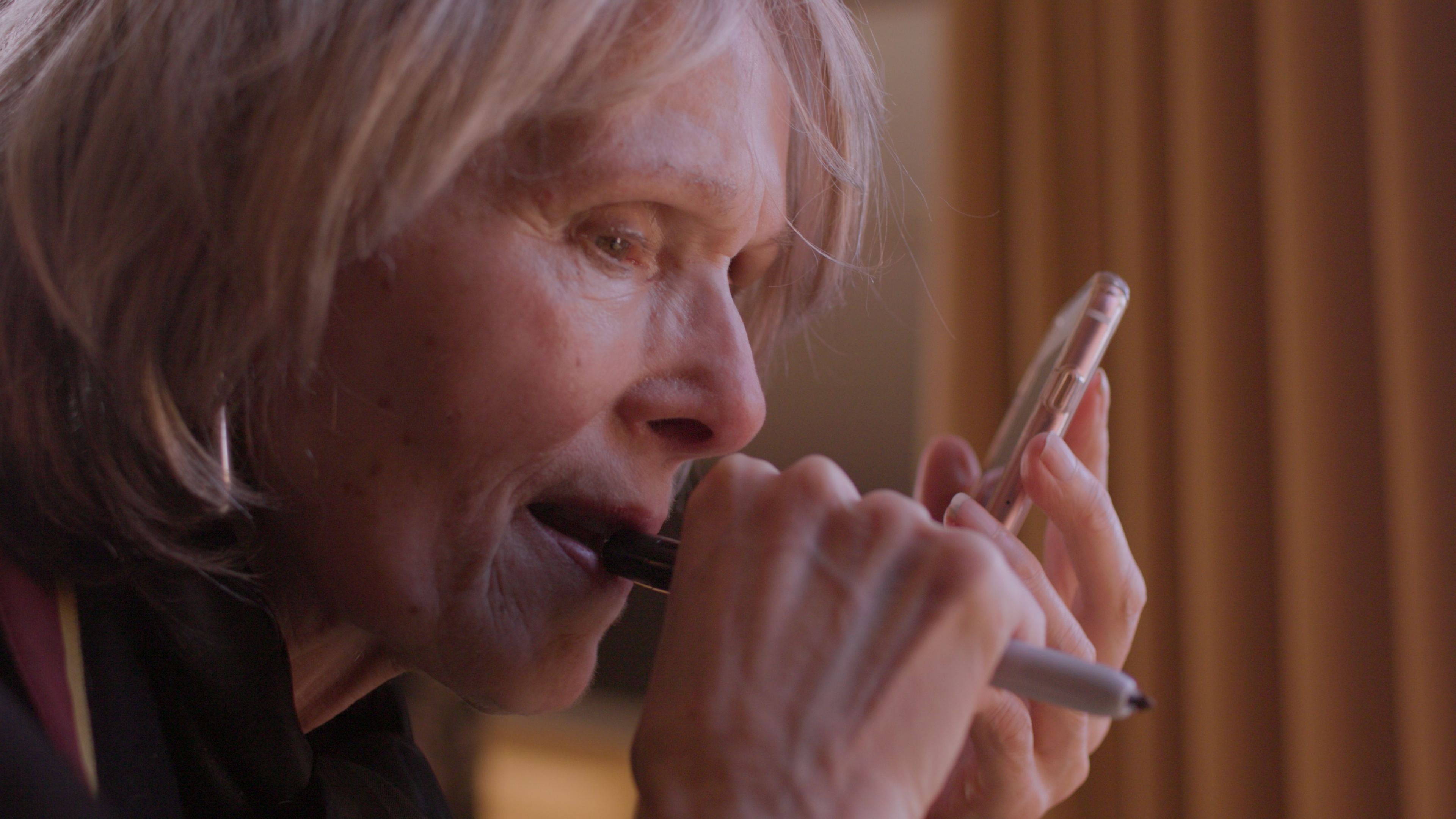 e jean carroll talks on the phone and looks tense in a still from the documentary ask e jean