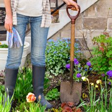 woman holding shovel in spring garden