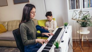 A girl is playing piano in the home living room
