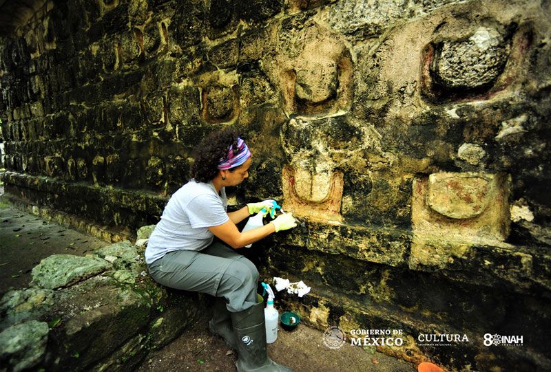 A researcher cleans the stucco exterior of a Maya remain in Kulub&aacute;, Mexico.