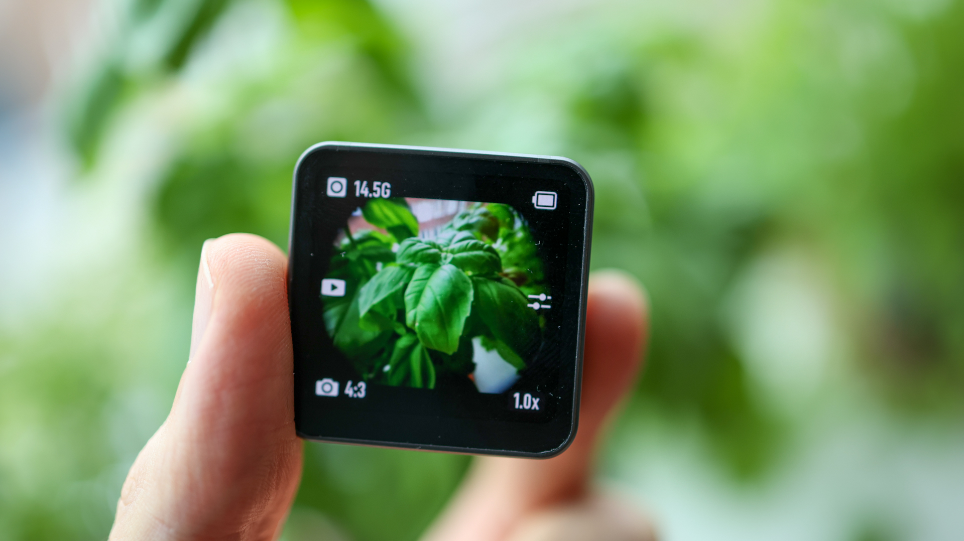 A hand holding the DJI Action 2 action camera