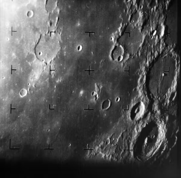 a rocky grey surface with craters and a grid of overlayed crosshair markers.