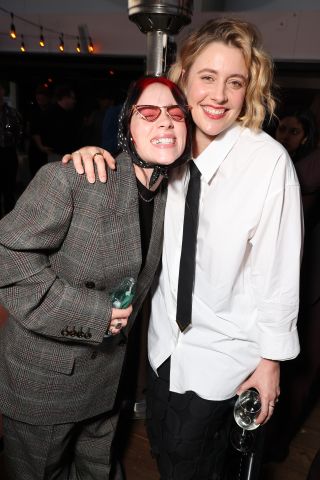 Greta Gerwig and Billie Eilish smiling for the camera and hugging.