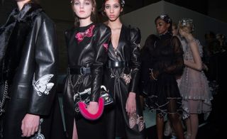 Female models wearing black leather jackets stood in a line