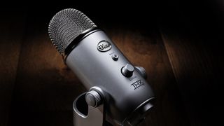 Close up of a Blue Yeti USB microphone in silver against a brown backdrop