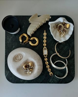 Jewelry items sitting in dishes on a table.