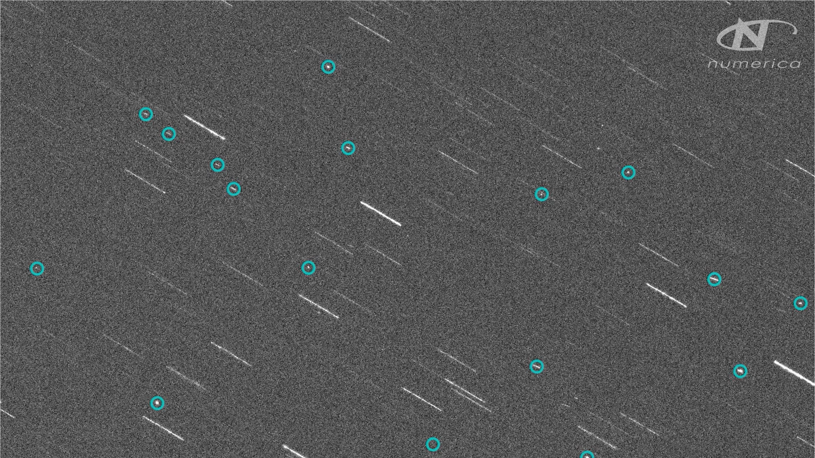 Telescope image of space debris from the Russian Cosmos 1408 satellite shortly after destruction. The image is grainy and grey, with debris circled in blue.