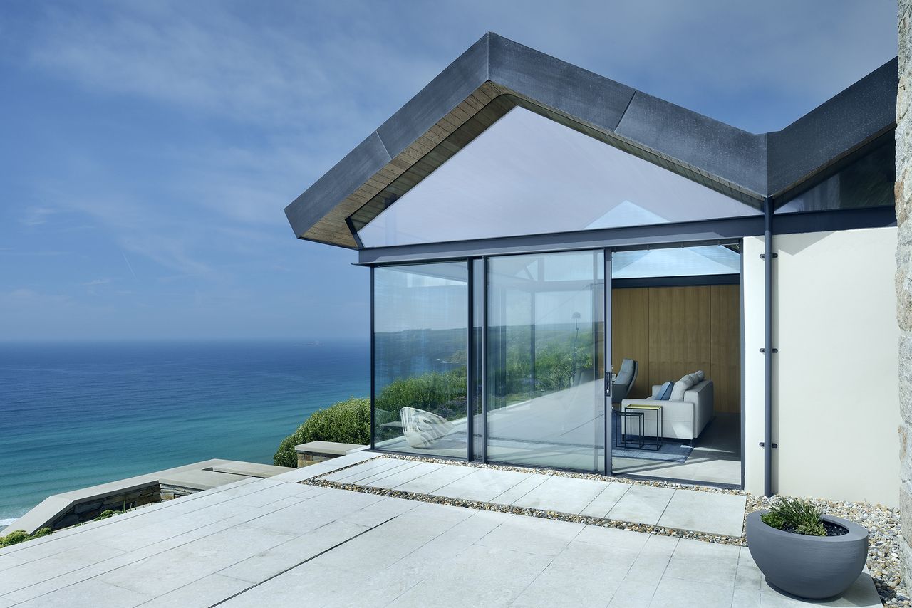 glass extension with pitched roof and view of sea