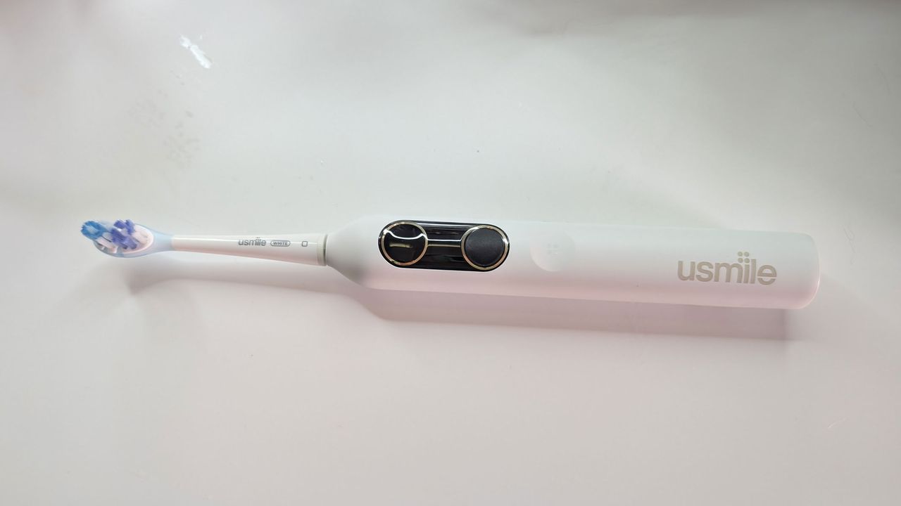 usmile Y10 PRO electric toothbrush laying flat on a white table