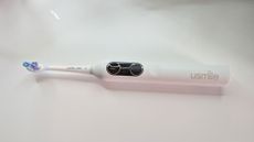 usmile Y10 PRO electric toothbrush laying flat on a white table
