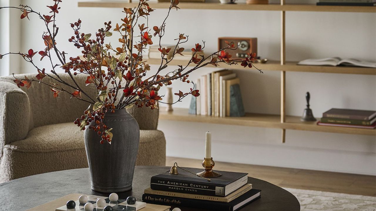 Magnolia Fall Sitting Room Décor - a coffee table with books and a vase of flowers in a sitting room