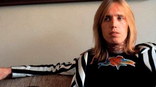 Tom Petty reclining on a sofa in 1977
