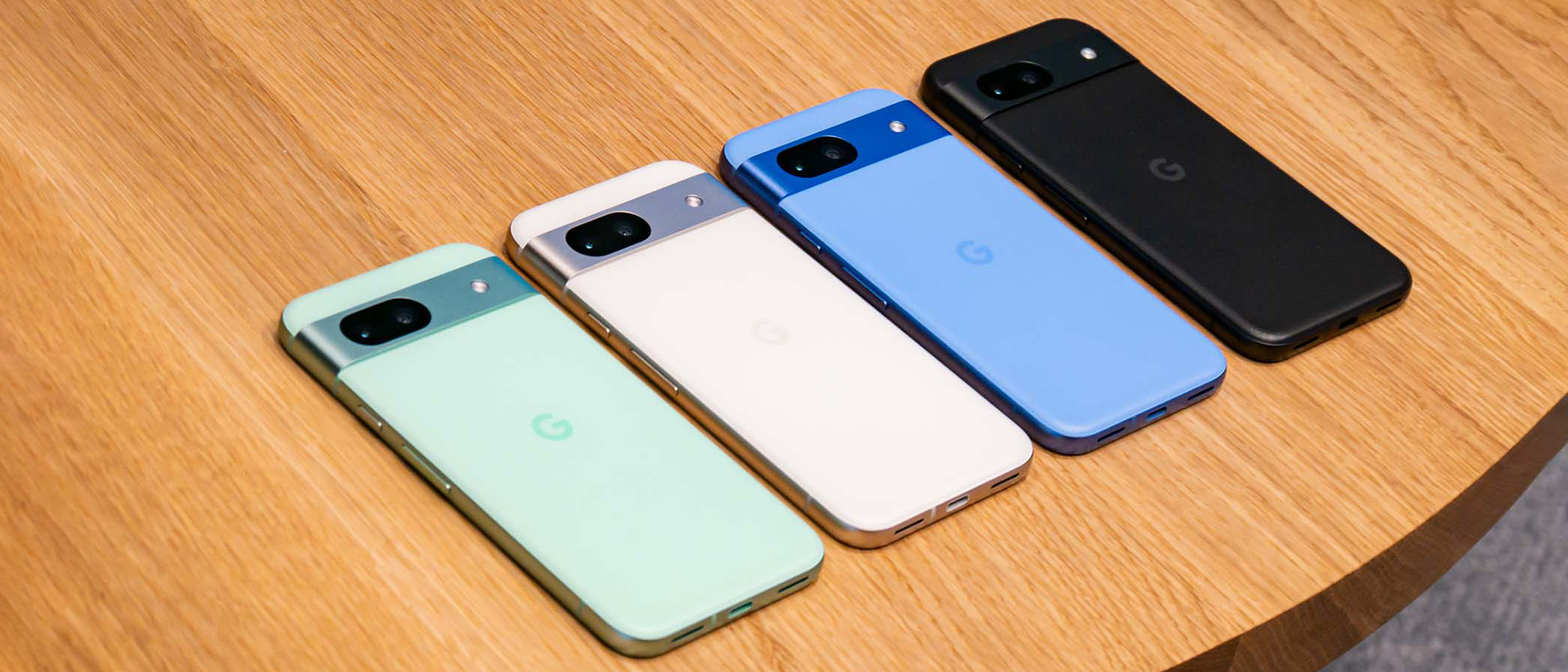 Google Pixel 8a in four colors shown on table.