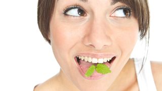 5 Causes of bad breath: image of woman smiling with mint