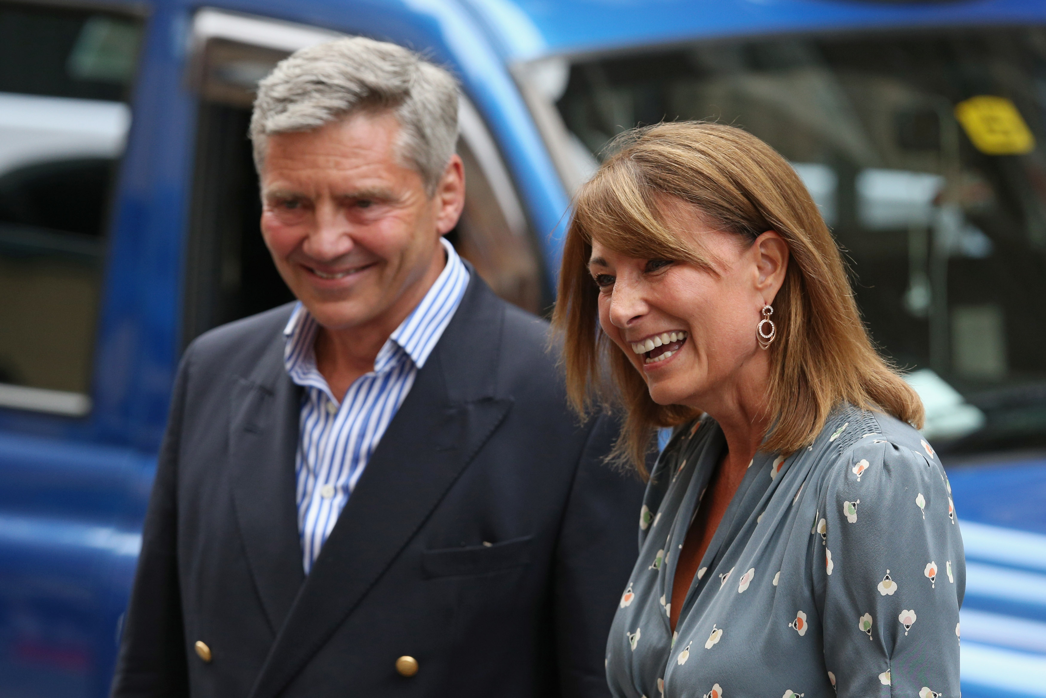 Carole and MIchael Middleton smiling in front of a blue truck