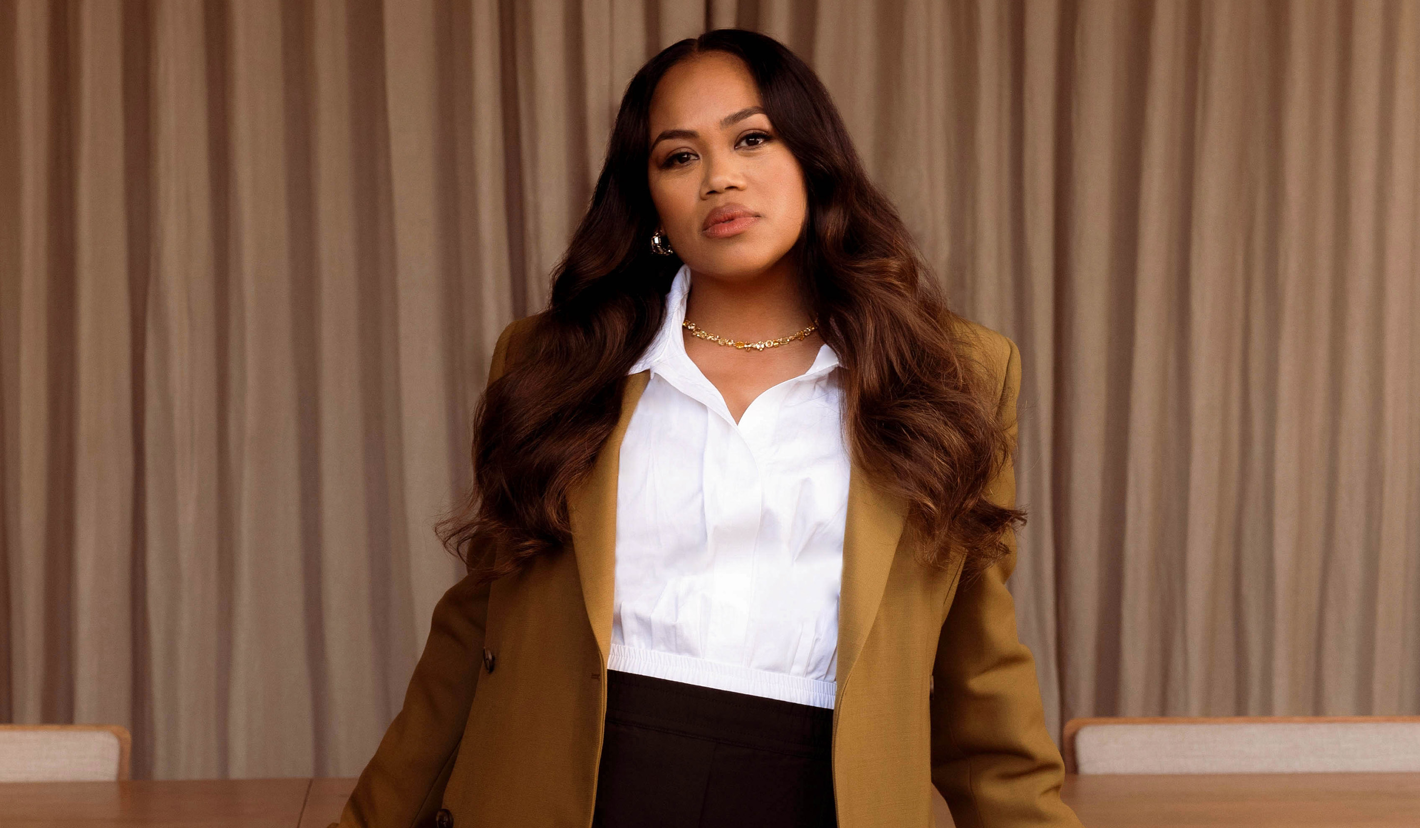 Zinzi Coogler wearing a crisp white shirt and a camel blazer