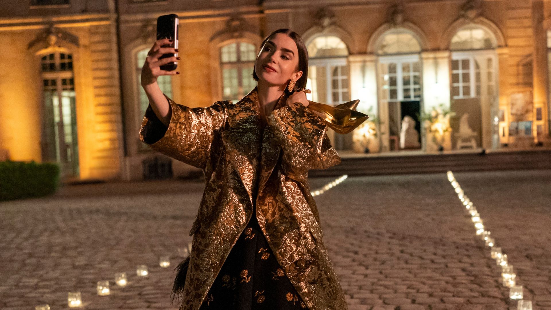 Emily takes a selfie on a candlelit path