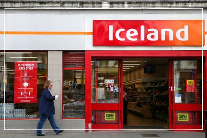 Woman walking by Iceland store front