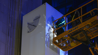 Workers remove the Twitter logo and name from the company's headquarters in San Francisco following its rebranding.
