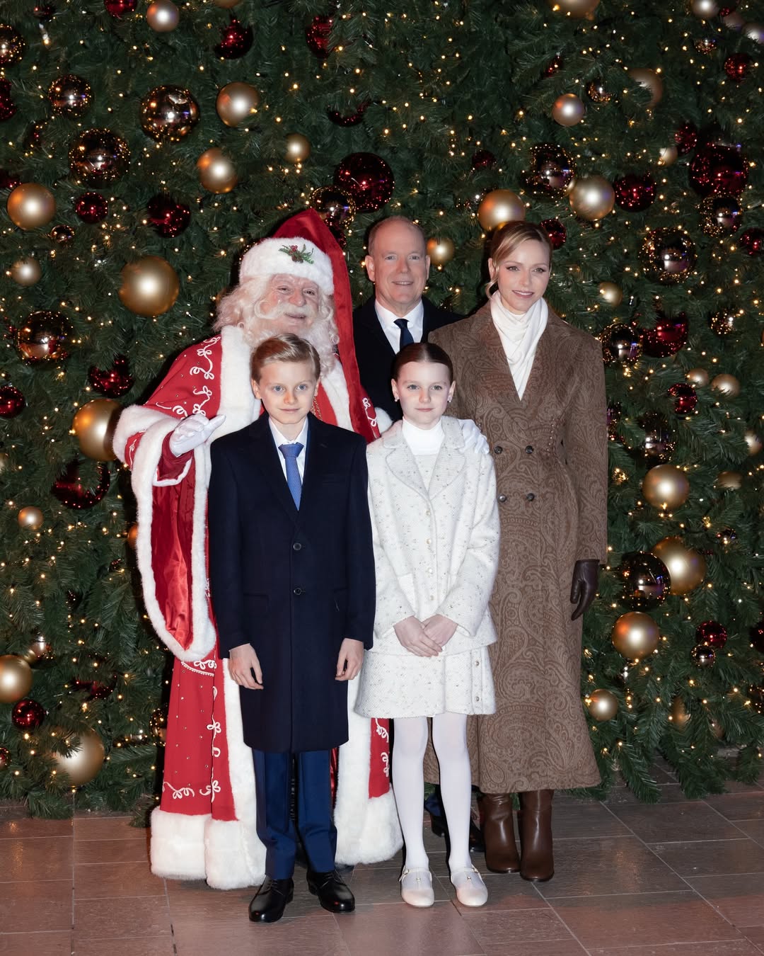 Santa, Prince Jacques, Princess Gabriella, Princess Charlene and Prince Albert in front of a Christmas tree