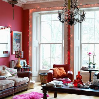 living room with pink wall white window and sofa with cushion