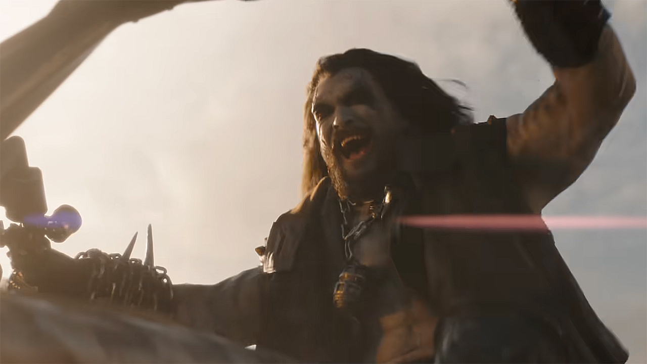 Lobo smiling and shouting as he rides his space-hog in Supergirl