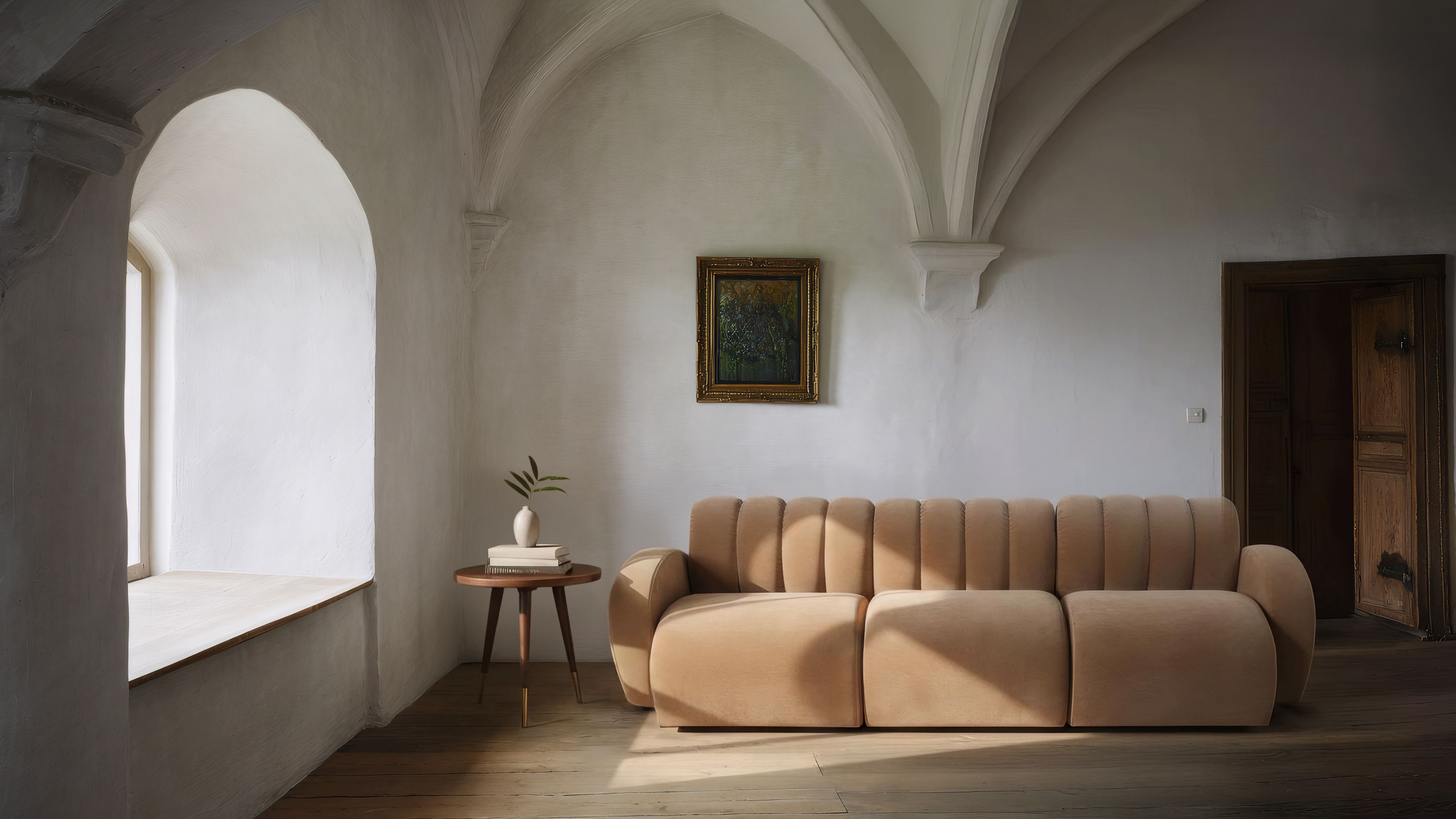 Schplendid tan sofa in a historic looking space with arched ceilings, an artwork hanging on the wall, and timber side table with vase of flowers