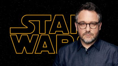 Colin Trevorrow in front of the Star Wars logo