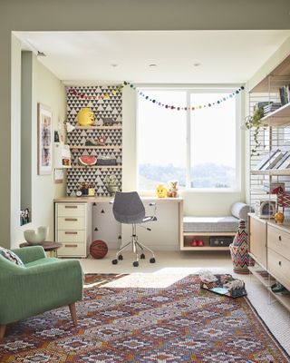 teen kids/bedroom ideas with wallpaper, desk, multicolored rug, green armchair, storage units