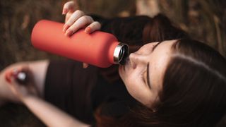 Woman drinking from metal bottle