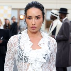 Demi Lovato wears a white lace skirt with black tights