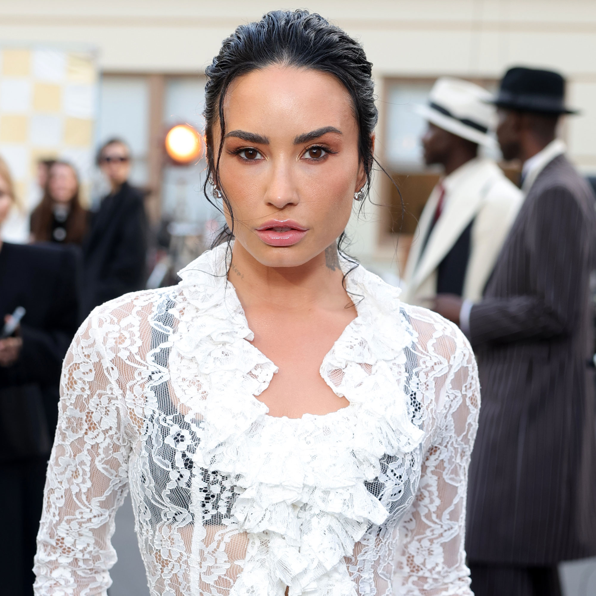 Demi Lovato wears a white lace skirt with black tights